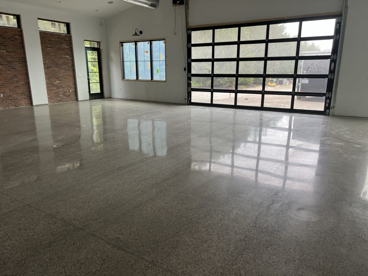 Polished concrete floor in a Michigan home with a high-gloss finish reflecting the windows